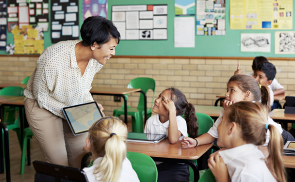 School teacher showing kids map on ipad