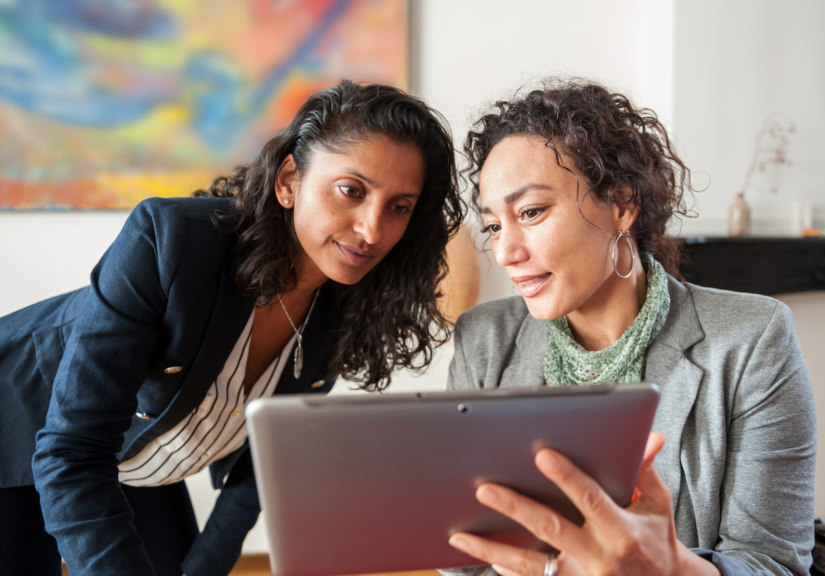 Two ladies looking at tablet in office